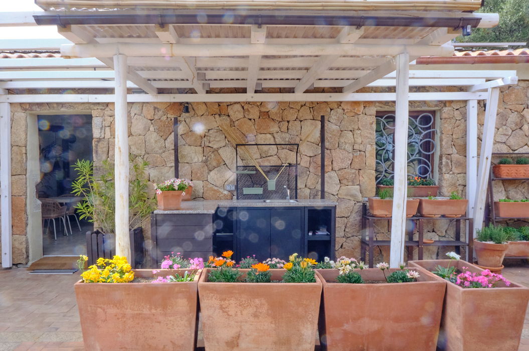 Pflanzkübel aus Terracotta befüllt mit bunten Blumen im Aussenbereich eines Ferienhaus auf Sardinien.