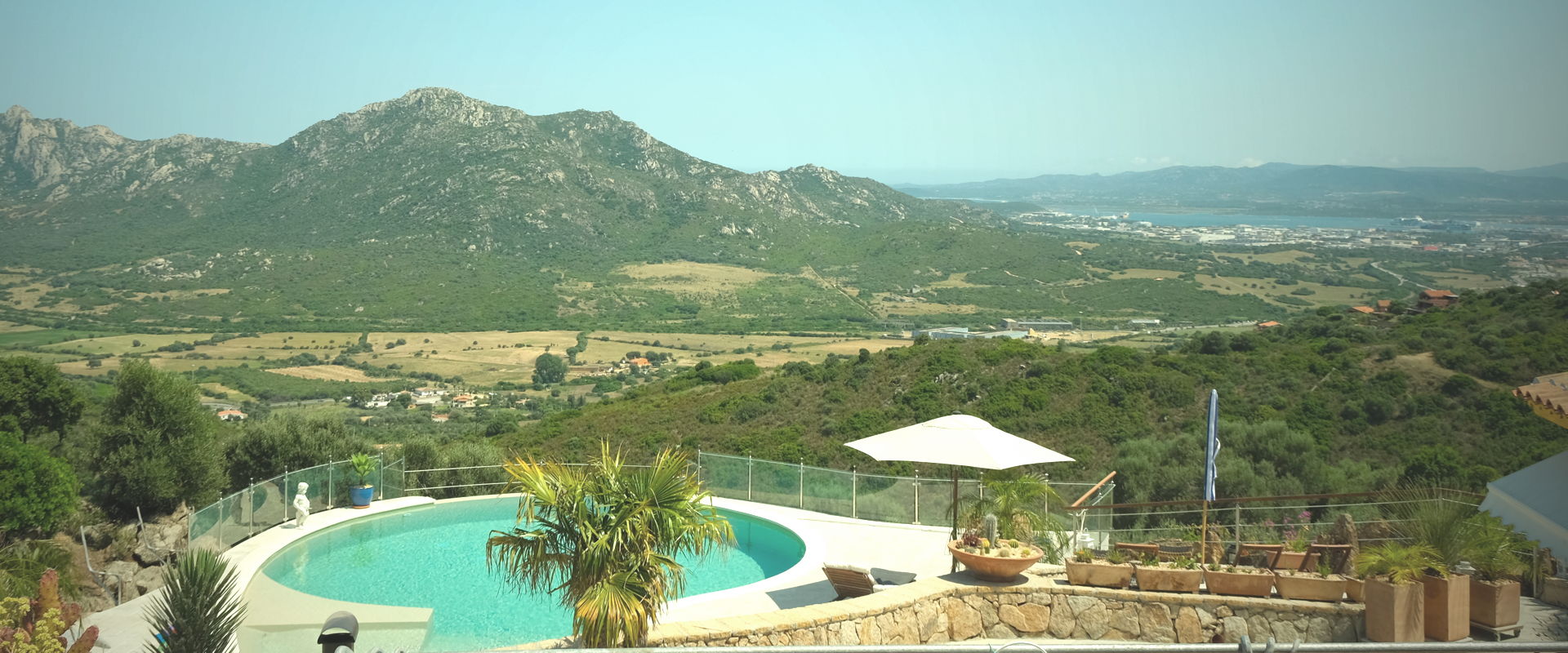 Panoramablick über den Swimmingpool der Villa Ella auf Sardinien auf die Berge rund um Oblia.